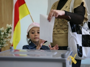 Woman casts ballot in the South Ossetian parliamentary election as her daughter watches (ITAR-TASS)